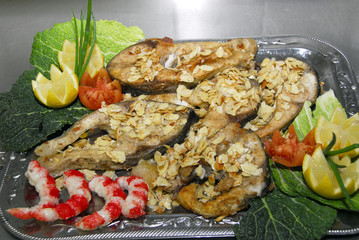 Fischplatte dekoriert mit Mandelsplittern und Garnelen