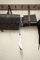 schultasche und gebündelte bücher an garderobenhaken