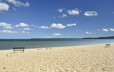 Fototapeta na wymiar lake Michigan beach with bench and cloudy sky