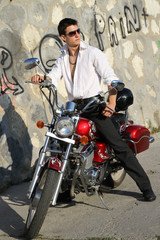 Obraz na płótnie Canvas young man on a red motorcycle