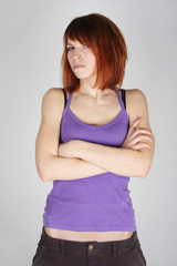 young redhead girl in purple shirt with crossed hands, dissatisf