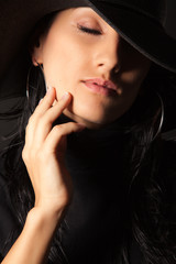 Attractive brunette girl in the hat gently touch your face