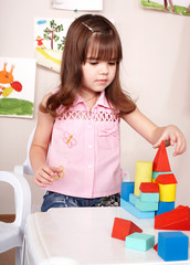 Child playing with wood  block  in  room.