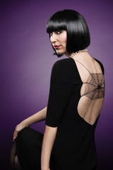 Fototapeta premium View of a young fashionable woman isolated on purple background