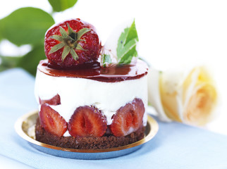 strawberry dessert with a yellow rose on a light blue napkin