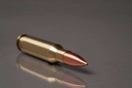 gun bullet lie on a grey bg