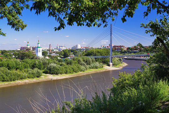 View of the river Tura, pedestrian bridge and church in Tyumen