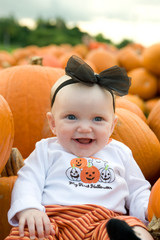 Adorable little girl in a pumpkin patch