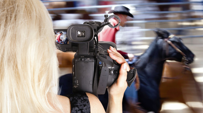 Blonde woman video recording horce race
