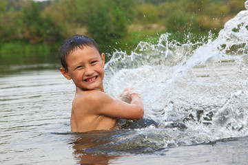 boy in river with splash