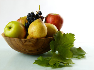 Obst vor weißem Hintergrund in Holzschale