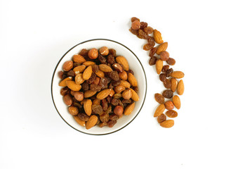 a bowl full of raisins, almonds and hazelnuts on white