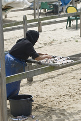 Mujer secando pescado.