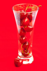 glass of cherry  on a red background