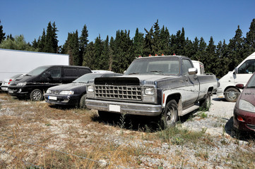 Fototapeta premium Abandoned parking with old vintage cars in field