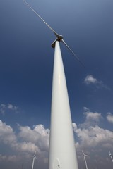 Wind turbine against a blue sky; wide-angle view