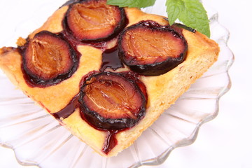 Piece of Plum Pie on a plate decorated with a mint twig