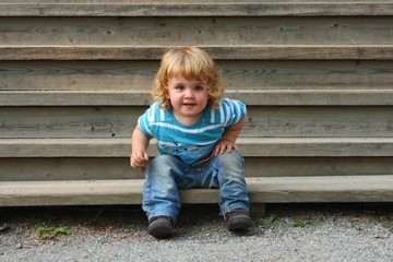 Kind sitzt auf einer Treppe