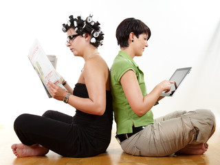 Girfriends reading newspaper and mobile device
