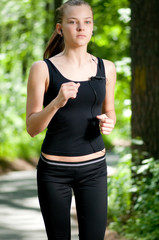 Beautiful woman running in green park