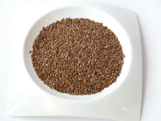 white plate full of brown flax seed or linseed