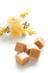 Caramel with lovely flower on white background