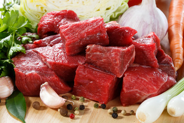Raw beef on cutting board and vegetables - obrazy, fototapety, plakaty