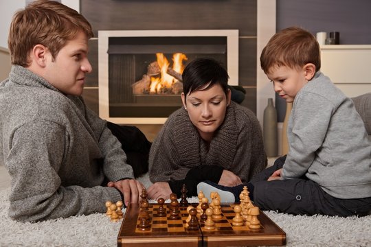 Young family playing chess