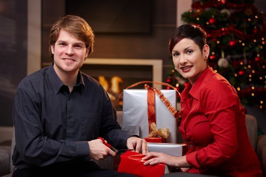 Young couple wrapping christmas gifts