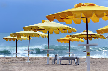 Yellow sun protecting umbrellas on a deserted beach