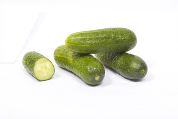 Four fresh cucumbers on a white background