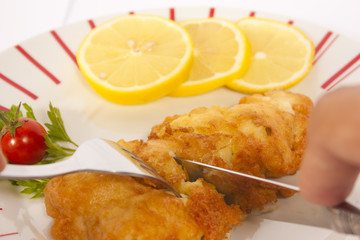 Fish schnitzel with lemon on a plate