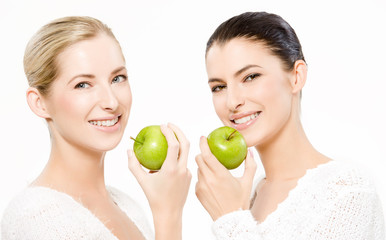 two smiling women with apples