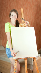 girl with brushes standing  near easel