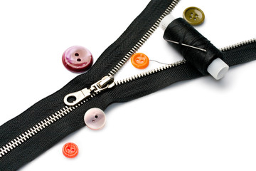 Zipper, thread and button isolated on white © Sergey Yarochkin