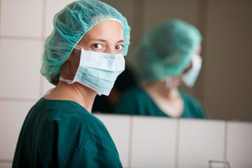 krankenschwester mit mundschutz vor dem spiegel