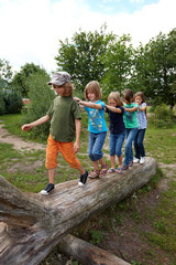 Kinder auf Baumstamm