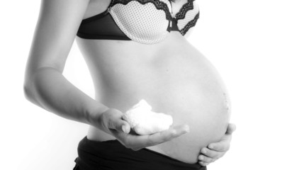 femme enceinte qui pr&eacute;sente des petits chaussons