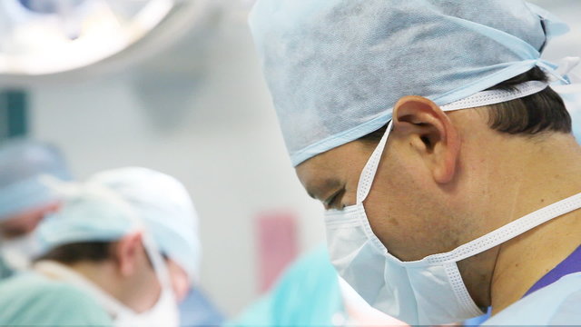 male surgeon with his team working in operation room