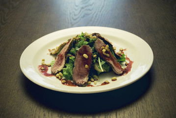 Meat with salad served on the white round  plate