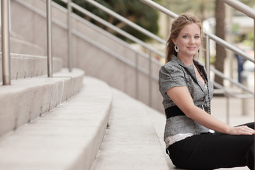 Sexy young woman sitting on the stairs