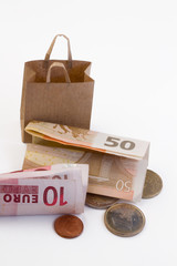 vor einer leeren Papiertüte liegt Geld