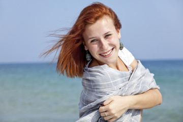 Young red-haired girl on the beach