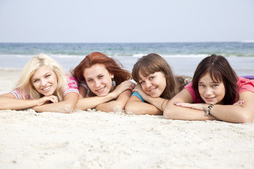 Girlfriends lying down at the beach.