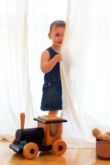 Shy child hidding behind a curtain
