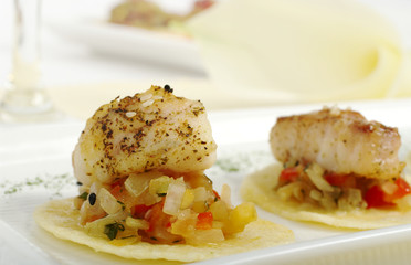 Piece of fish on vegetables and chip (Selective Focus)