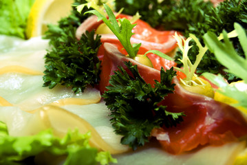 Appetizer with fish served with salad and lemon