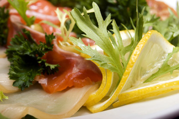 Appetizer with fish served with salad and lemon