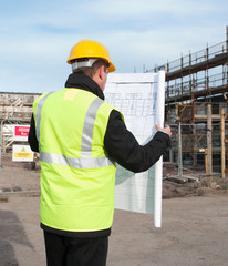 Rear view of architect looking down at plans