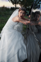 bride in white being kidnapped into a car in the evening